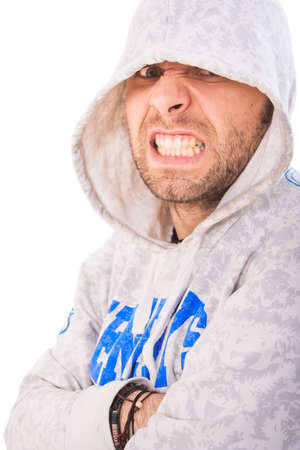 portrait of handsome bearded european guy in grey hoody making angry face showing bared teethの写真素材