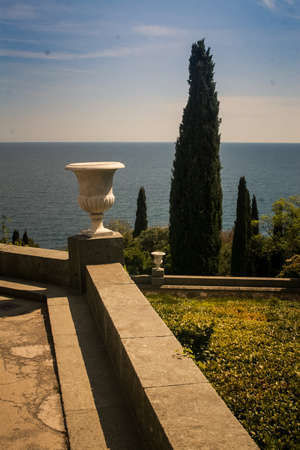 Crimea Vorontsov palace park with marble vase and cypress against azure sea in springtimeのeditorial素材