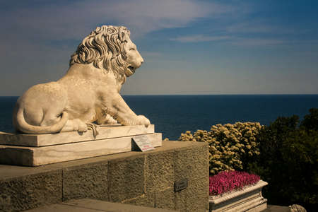Vorontsov palace closeup side view old marble lion sculpture in park against azure sea and blue sky in Crimeaのeditorial素材