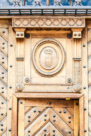 closeup age-old light brown wooden fretwork door with metal decorationの写真素材
