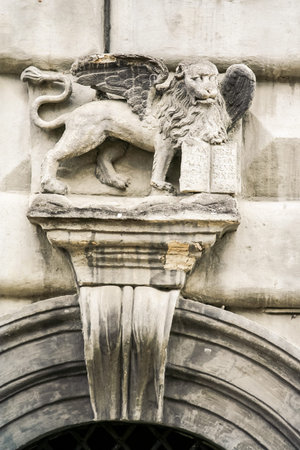 closeup lion with wings stone sculpture over marble entrance arch in age-old buildingの写真素材