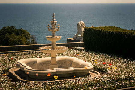 three level fountain among flowers in park of Vorontsov palace against azure sea in Crimea Ukraine in springのeditorial素材