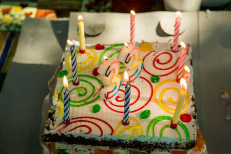 birthday colorful creamy and jelly cake with inflamed candlesの写真素材