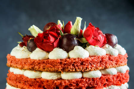 closeup top of beautiful multi-layer cake with white bizet, grapes and red and white rosesの写真素材