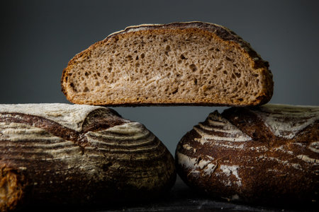 closeup three pieces of delicious homemade round rye bread on gray background