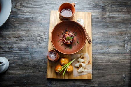 top view of traditional ukrainian plate with salad next to baked doughnut with garlic topping decorated with green onion and sliced tallowの写真素材