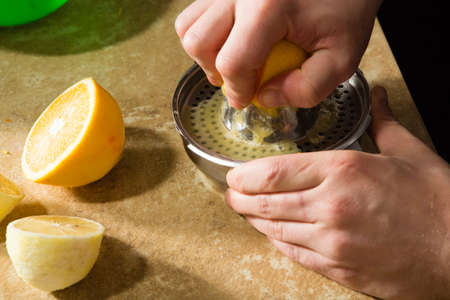 process of manual extraction of fresh lemon juice with squeezerの写真素材