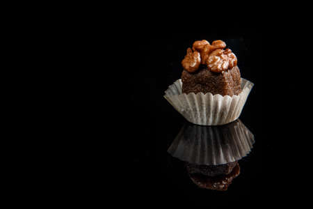 closeup healthy useful organic handmade candy decorated with walnut on black mirror backgroundの写真素材