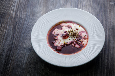homemade borscht decorated with sour cream and wheat sprouts served in white restaurant profound...