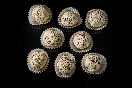 top view on group of healthy useful round organic handmade candy decorated with white sesame seeds...