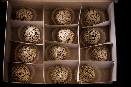 homemade box filled with healthy useful round organic handmade candy decorated with white sesame...