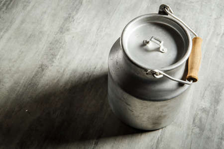 top view of old kind of aluminum bidon with wooden handle for milk storage on gray backgroundの写真素材