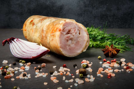 closeup chunk of minced meat roll served with pink salt, aromatic spices, fresh green dill and sliced red onionの写真素材
