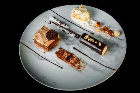 top view of sweet chocolate and white cream mousse dessert served on round plate on black background