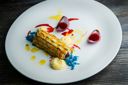 modern decorated vegetable roll stuffed with minced meat served with assorted sauces on white plate...