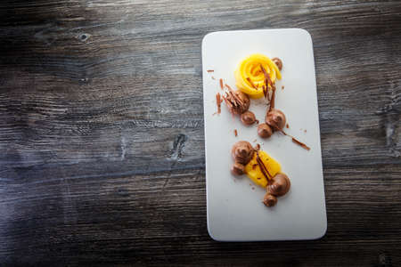 top view exclusive restaurant fruit and chocolate mousse dessert served on white original plate on wooden table plateの写真素材