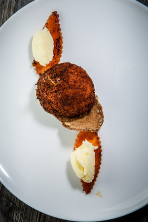 top view vertical on delicious chicken kiev cutlet with mashed potato garnish and dark bread slice...