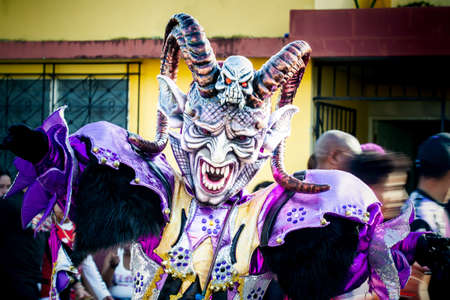 Concepcion De La Vega, DOMINICAN REPUBLIC - FEBRUARY 09, 2020: adult man in scary demon mask and costume poses for photo at dominican carnival on February 9 in Concepcion De La Vegaのeditorial素材