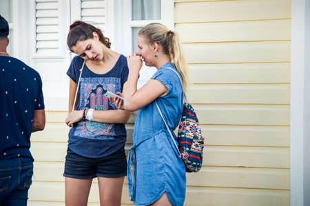 Concepcion De La Vega, DOMINICAN REPUBLIC - FEBRUARY 09, 2020: white young tourist girls in casual clothes talk on city street at dominican carnival on February 9 in Concepcion De La Vegaのeditorial素材