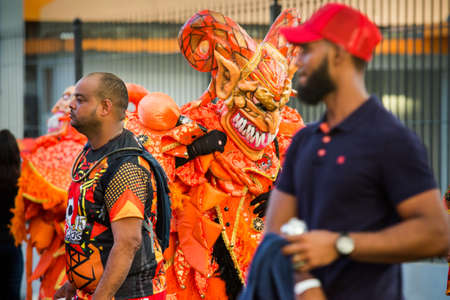 Concepcion De La Vega, DOMINICAN REPUBLIC - FEBRUARY 11, 2019: closeup men in vivid masquerade costumes pass by city street at dominican carnival on February 11 in Concepcion De La Vegaのeditorial素材