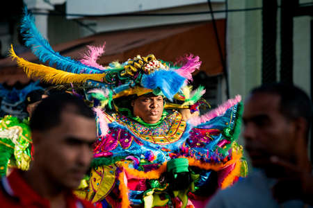 Concepcion De La Vega, DOMINICAN REPUBLIC - FEBRUARY 09, 2020: closeup big man in varicolored costume walks by city street at dominican carnival on February 9 in Concepcion De La Vegaのeditorial素材