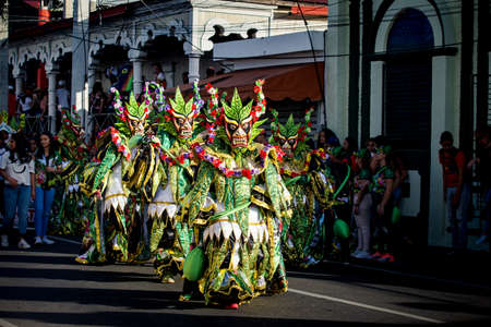 Concepcion De La Vega, DOMINICAN REPUBLIC - FEBRUARY 09, 2020: group of people in pied green costumes walk by city street at dominican carnival on February 9 in Concepcion De La Vegaのeditorial素材