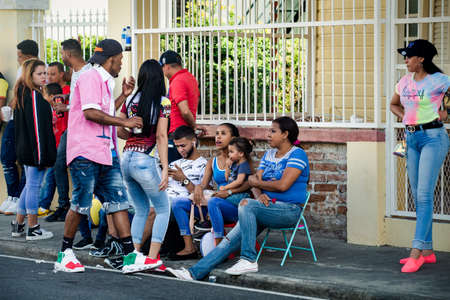 Concepcion De La Vega, DOMINICAN REPUBLIC - FEBRUARY 09, 2020: many native people in bright clothes relaxing at city street at dominican carnival on February 9 in Concepcion De La Vegaのeditorial素材
