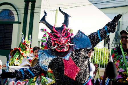 Concepcion De La Vega, DOMINICAN REPUBLIC - FEBRUARY 09, 2020: man in scary demon costume poses for photo on city street at dominican carnival on February 9 in Concepcion De La Vegaのeditorial素材
