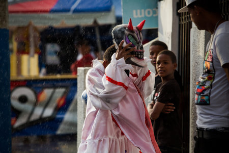Concepcion De La Vega, DOMINICAN REPUBLIC - FEBRUARY 11, 2019: young boy in devil costume hides from...