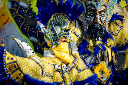 Concepcion De La Vega, DOMINICAN REPUBLIC - FEBRUARY 09, 2020: closeup young people in motley costumes pass by city street at dominican carnival on February 9 in Concepcion De La Vegaのeditorial素材