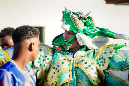 Concepcion De La Vega, DOMINICAN REPUBLIC - FEBRUARY 09, 2020: closeup adult man in bright green costume walks by city street at dominican carnival on February 9 in Concepcion De La Vegaのeditorial素材