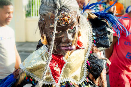 Concepcion De La Vega, DOMINICAN REPUBLIC - FEBRUARY 09, 2020: closeup man in vivid carnival costume poses for photo on dominican city street on February 9 in Concepcion De La Vegaのeditorial素材