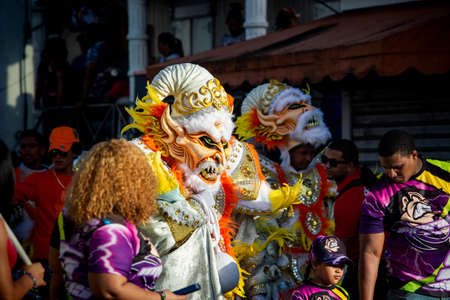 Concepcion De La Vega, DOMINICAN REPUBLIC - FEBRUARY 09, 2020: closeup people in flamboyant costumes pass by city street at dominican carnival on February 9 in Concepcion De La Vegaのeditorial素材