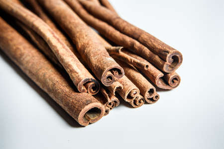 closeup big group of dry long light brown textured cinnamon sticks served on white table surfaceの写真素材
