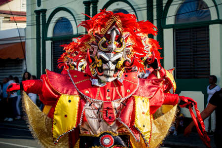 closeup man in vivid costume poses for photo on city street at dominican carnivalのeditorial素材