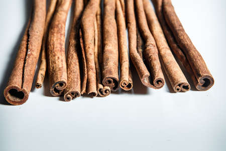 closeup big heap of dry cinnamon sticks served on white table surfaceの写真素材