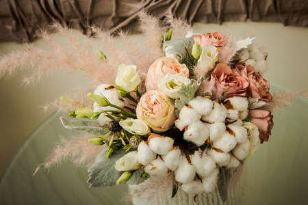 closeup exquisite bouquet of white cotton flowers and assorted rosesの写真素材