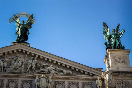 closeup different sculptures adorn front of national opera and ballet theatre against clear blue sky in Lviv, Ukraineの写真素材