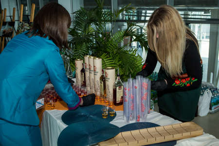 LVIV, UKRAINE - MAY 24, 2018: women serving alcohol on table for degustation in Lviv international airport hall on May 24 in Lvivのeditorial素材