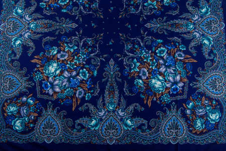 horizontal top view part of bright blue paisley floral pattern on dark blue cotton female shawlの写真素材