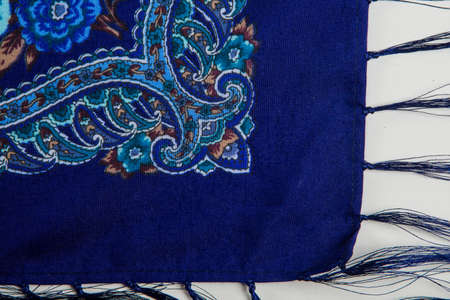 top view part of bright paisley floral pattern on dark blue cotton female shawl on white backgroundの写真素材