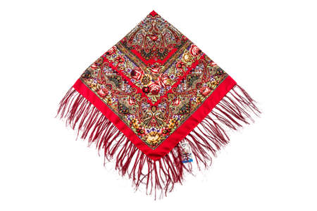 top view on flat lay red cotton scarf with fringe and bright paisley floral ornament with yellow, purple and green colors lay on isolated white backgroundの写真素材