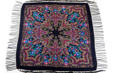 top view on flat lay black cotton scarf with fringe and bright paisley floral ornament with pink, blue and yellow colors on isolated white backgroundの写真素材