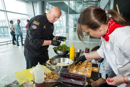 LVIV, UKRAINE - MAY 24, 2018: different chefs in uniforms serving snacks on table for degustation in Lviv airport hall on May 24 in Lvivのeditorial素材