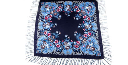 top view on flat beige cotton scarf with fringe and bright floral ornament with golden, brown and yellow colors lay on white backgroundの写真素材