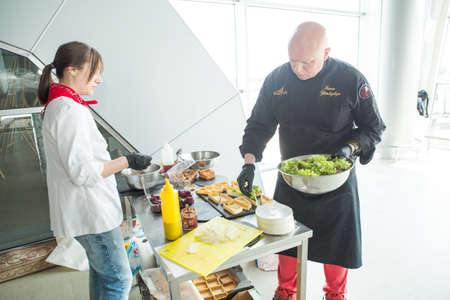 chefs in different uniforms serving snacks on table for degustation in Lviv airport hallのeditorial素材