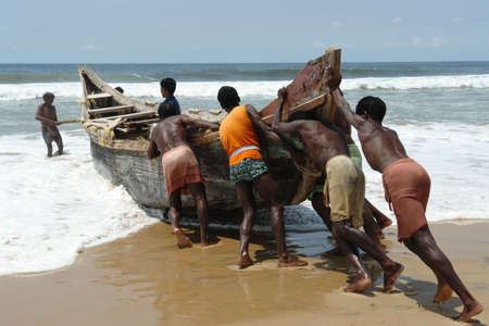 Indian fishermen pushing the boatの写真素材