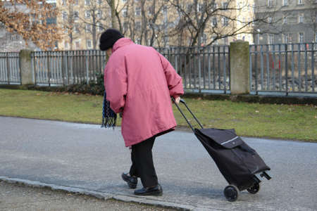Lonely old woman are walking down the street  の写真素材
