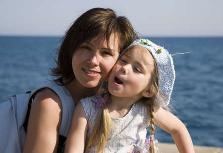 Portrait of mother and daughter against a background of the sea  の写真素材