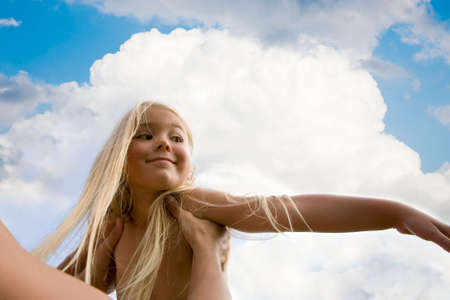 Portrait of little girl against a background of the sky  の写真素材